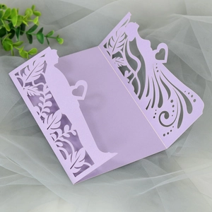 Detail of laser-cut wedding invitation showing intricate floral patterns and couple silhouette