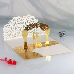Detailed macro view of laser-cut 3D wedding invitation featuring gold foil rose archway