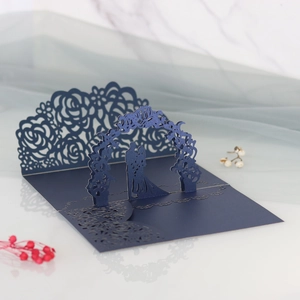 Dettaglio dell'invito di nozze 3D blu navy tagliato al laser con coppia sotto un arco