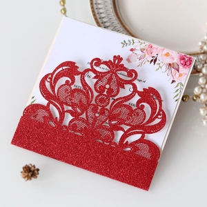 Close-up of red glitter laser-cut lace wedding invitation with floral printed insert