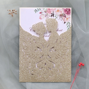 Detail of laser-cut gold glitter wedding invitation with bride and groom silhouette