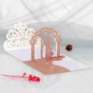 3D Laser-Hochzeitseinladung mit roségoldener Glitzer-Silhouette eines Brautpaares