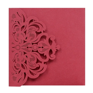 Detail of laser-cut lace pattern on elegant dark red cardstock wedding invitation