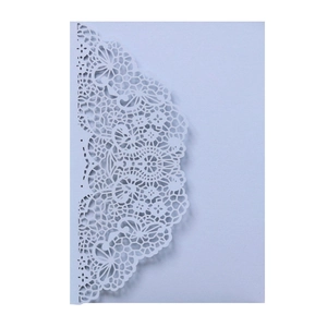 Close-up of laser-cut lace floral pattern on light purple wedding invitation card