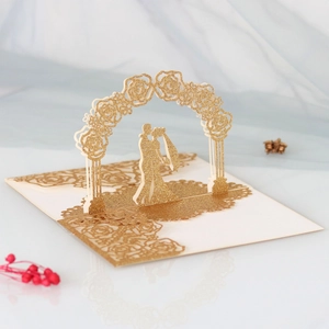 Macro view of 3D laser cut wedding invitation with glitter rose arch and bridal couple