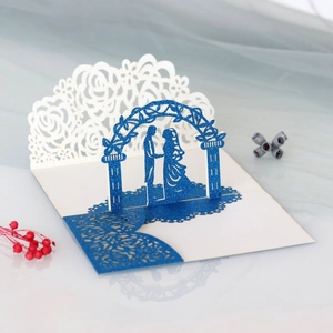 Detail of 3D laser-cut wedding card featuring a romantic couple under floral arch