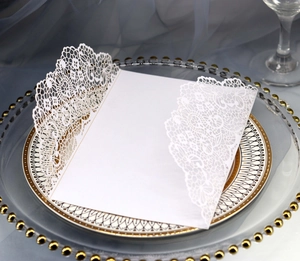 Détail de l'invitation de mariage blanche découpée au laser avec motif dentelle floral