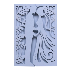 Macro shot of laser-cut light blue wedding invitation with kissing couple silhouette