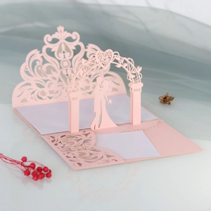 Detail of pink 3D laser-cut wedding invitation featuring romantic lace and gate pattern