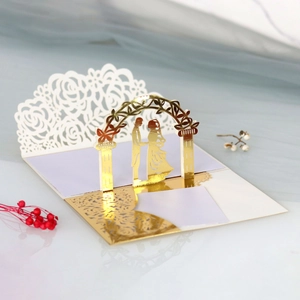 Dettaglio invito nozze 3D con motivi a rose dorate e silhouette tagliate al laser con cura