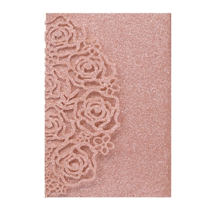 Intricate laser-cut rose floral design on glittery rose gold wedding invitation card