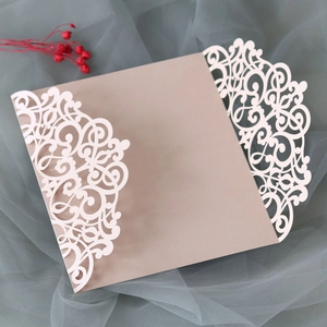 Detail of laser-cut filigree butterfly wedding invitation on soft green tulle fabric