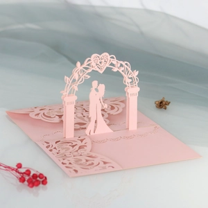 Detail of 3D laser cut pink wedding card with floral archway and intricate lace design