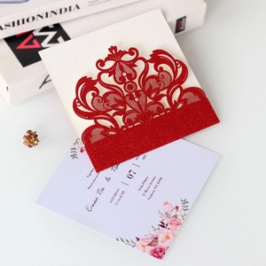 Detail of red glitter laser cut wedding invitation with elegant floral inner card
