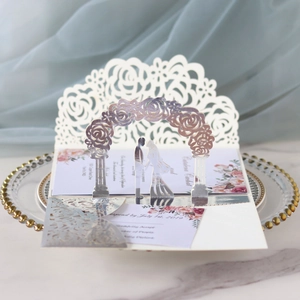 Macro detail of 3D laser-cut silver wedding invitation with rose arch and couple silhouette