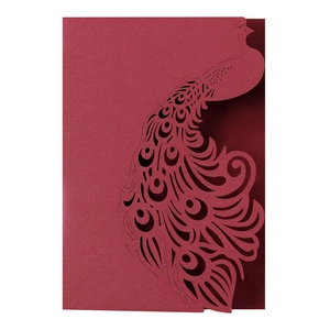 Detail of laser-cut peacock pattern on burgundy wedding invitation card with pearlescent finish