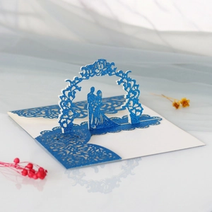 Détail d'une carte de mariage 3D bleue à paillettes avec couple sous une arche de fleurs