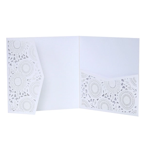 Detail of white laser-cut wedding invitation with intricate floral lace patterns and pocket