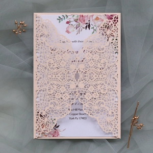 Détail d'invitation de mariage en dentelle découpée au laser avec carte intérieure à fleurs