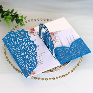 Intricate laser-cut blue glitter wedding invitation with elegant floral insert card