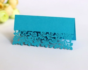 Detail showing the intricate laser-cut floral pattern on a blue cardstock table tent