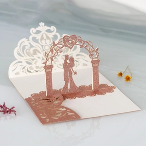 Detail of laser cut 3D pop-up wedding invitation featuring a rose gold glitter silhouette