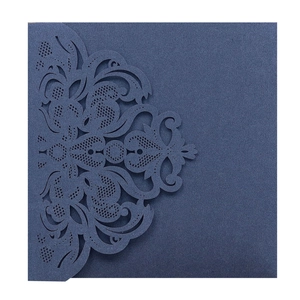 Macro detail of laser-cut lace pattern on navy blue pearlescent wedding invitation card