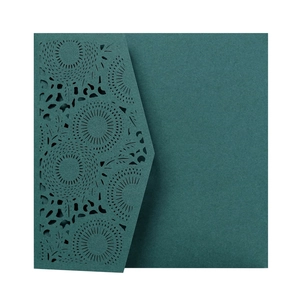 Detail of laser-cut intricate circular patterns on dark green wedding invitation card