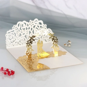 Dettaglio di un biglietto di nozze 3D con scena romantica in lamina d'oro e pizzo laser