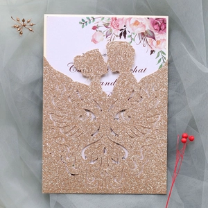 Detail of laser-cut gold glitter wedding invitation with elegant bride and groom silhouette