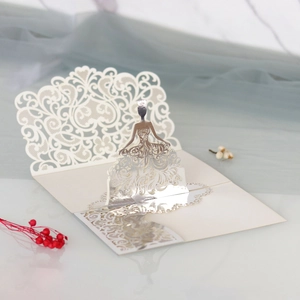Detailed laser cut 3D pop-up wedding invitation card featuring lace gown and silver accents