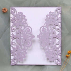 Detail of laser-cut lavender floral wedding invitation with white insert on mesh background