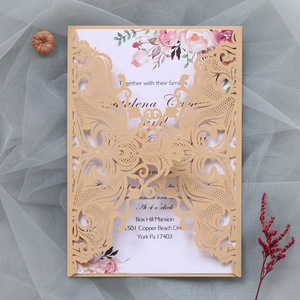 Detailed laser-cut wedding invitation featuring elegant floral patterns and gold accents