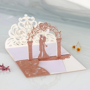 Detailed laser-cut rose gold wedding invitation with silhouettes and floral arch