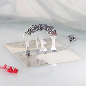 Macro view of 3D laser-cut wedding invitation featuring rose arch and couple silhouette