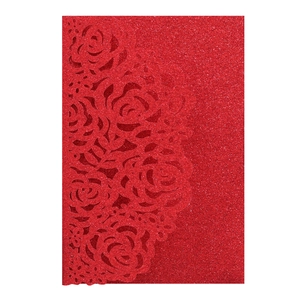 Detail of red glitter laser-cut rose hollow invitation cover with sparkly texture