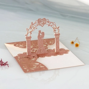 Detailed 3D laser-cut wedding card featuring a rose gold glitter couple silhouette and arch