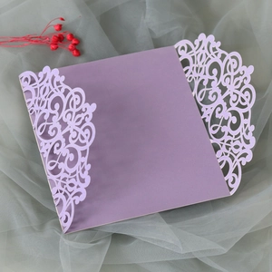 Macro detail of laser-cut butterfly wedding invitation card in light purple pearlescent paper