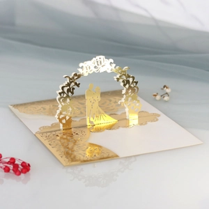 Dettaglio dell'invito di nozze 3D con arco floreale dorato e sagoma di coppia tagliata a laser