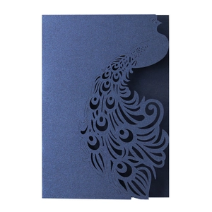 Macro detail of dark blue laser-cut peacock wedding invitation with pearlescent texture