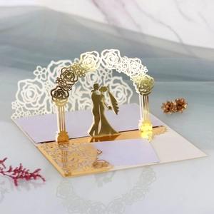 3D laser-cut wedding invitation showing a couple kissing under a rose arch detail