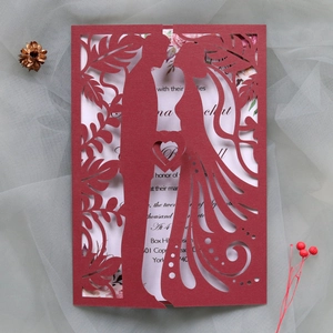 Detailed laser-cut burgundy wedding invitation featuring a bride and groom silhouette