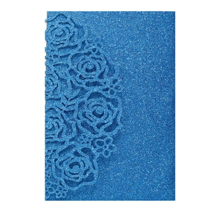 Detailed laser-cut rose pattern on royal blue glitter cardstock for wedding invitations