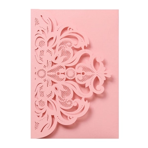 Close-up of pink laser-cut lace wedding invitation card with intricate floral details