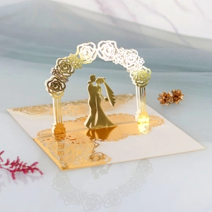 Intricate laser-cut 3D wedding card featuring a romantic couple silhouette under a floral arch