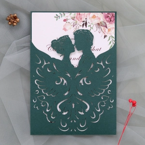 Detail of laser-cut wedding invitation featuring a kissing couple and floral inner card