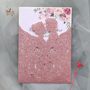 Detail of pink glitter laser-cut wedding invitation with romantic silhouette and floral card