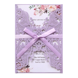 Detail of light purple laser cut lace wedding card with satin ribbon bow and floral insert