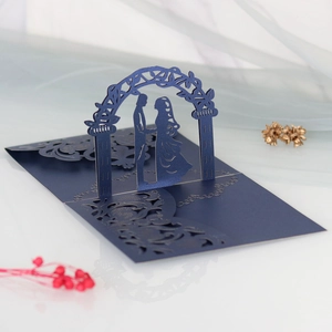Intricate laser-cut 3D wedding invitation featuring a romantic couple under an archway