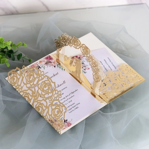 Detail of 3D laser-cut wedding invitation with golden rose patterns and a romantic silhouette